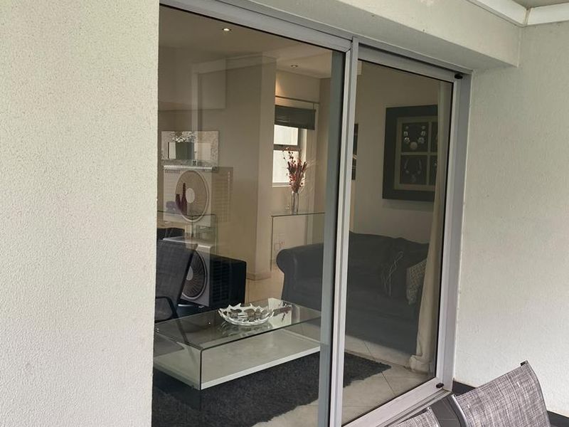 A covered patio area featuring tiled flooring and a large sliding glass door providing access to the interior living space.