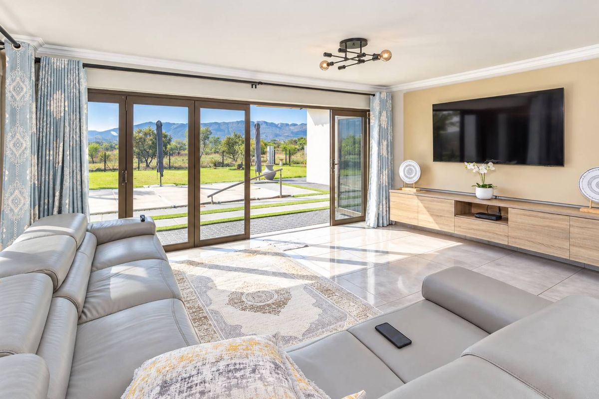 Bright living room featuring large sliding glass doors that open to a patio, tiled floors, and custom built-in cabinetry with mountain views.