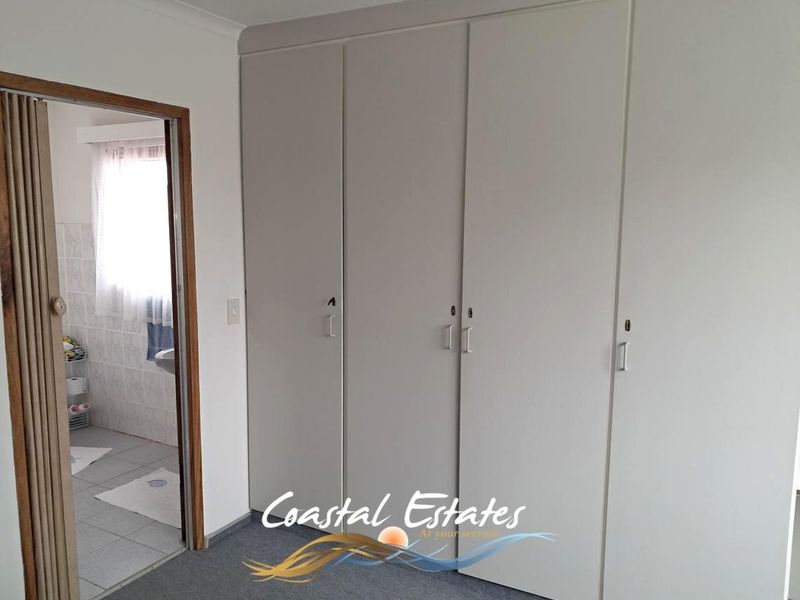 A bedroom featuring built-in cupboards and a folding door leading to an adjacent bathroom.