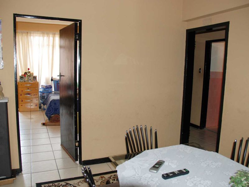 A living area featuring tiled flooring and access to adjacent rooms through standard door frames.