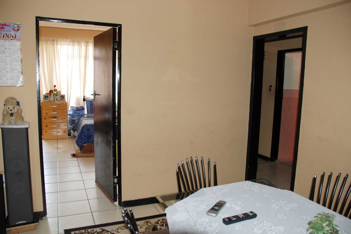 A living area featuring tiled flooring and access to adjacent rooms through standard door frames.