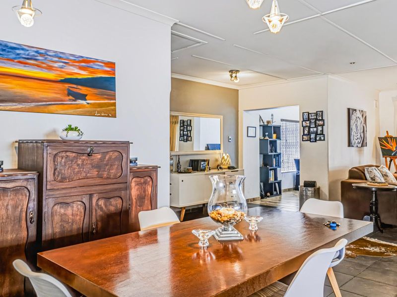 An open-plan living and dining area featuring tiled flooring, coved ceilings, and a neutral color palette, providing a versatile space for family living.