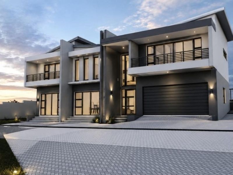 Modern double-storey residential facade featuring a paved driveway, double garage, and upper-level balconies with contemporary architectural design.