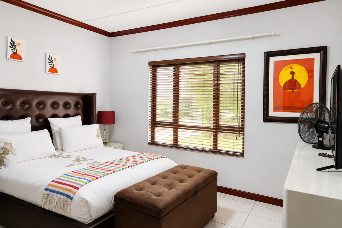 A well-maintained bedroom featuring tiled flooring, timber crown molding, and timber window blinds, providing a clean and functional living space.