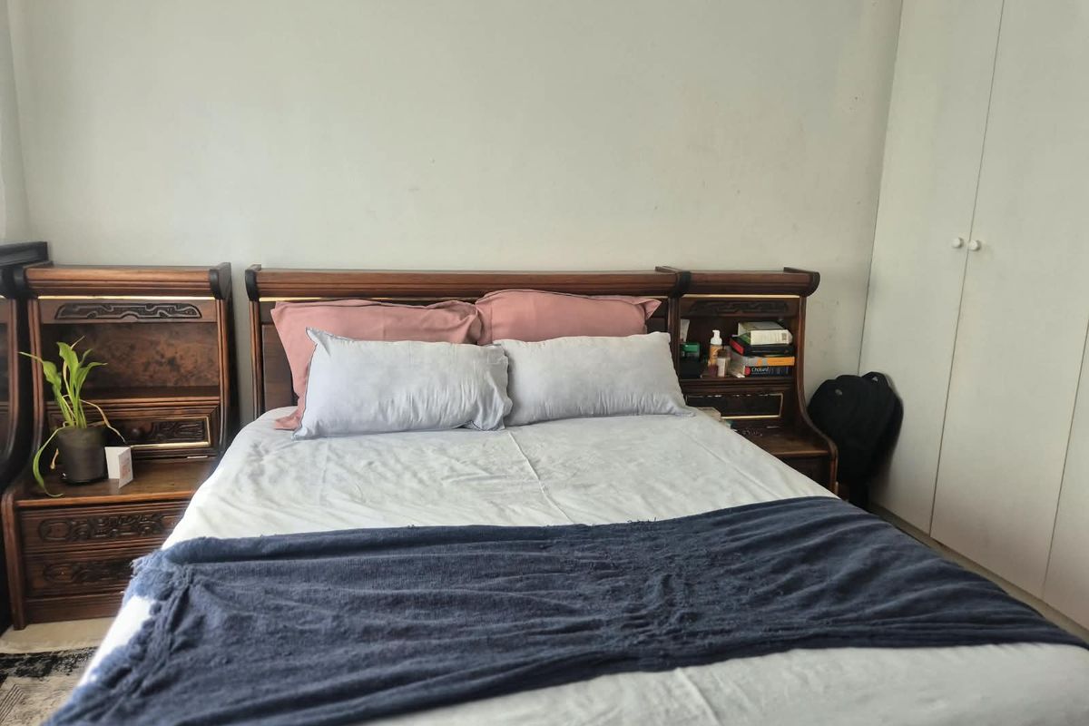 A bedroom featuring a built-in wardrobe with white doors and neutral wall finishes.