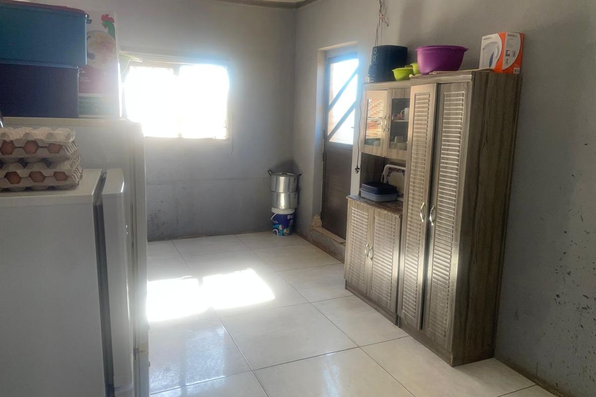 A functional kitchen space featuring tiled flooring and built-in cabinetry, offering a blank canvas for potential renovation and modernization.