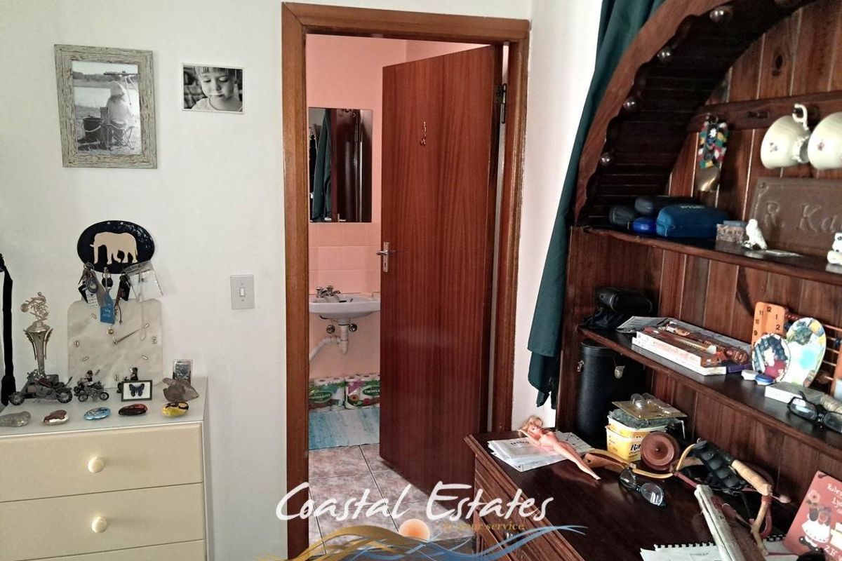 A view from a bedroom looking into an en-suite bathroom featuring a wall-mounted basin and wooden door frame.