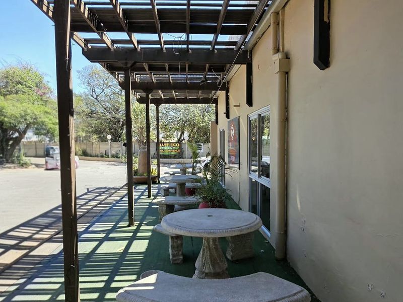 Covered outdoor patio area featuring a timber pergola structure and direct access to the building interior via sliding glass doors.
