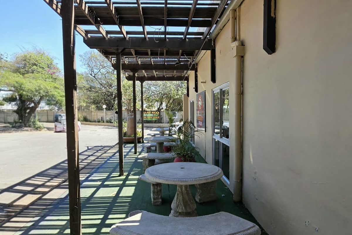 Covered outdoor patio area featuring a timber pergola structure and direct access to the building interior via sliding glass doors.
