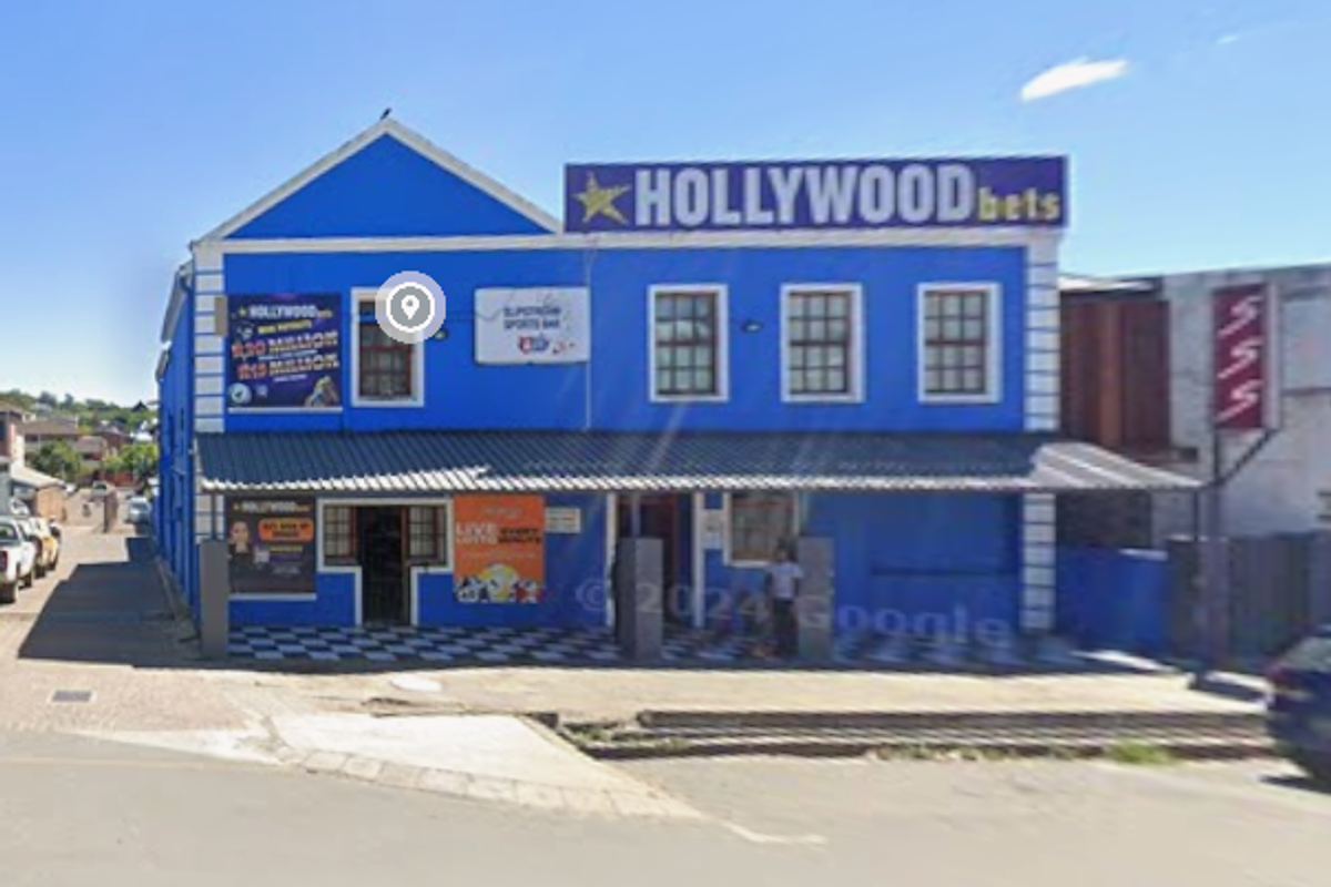 Front elevation of a commercial building featuring a covered veranda, checkerboard tiled entrance, and prominent signage.