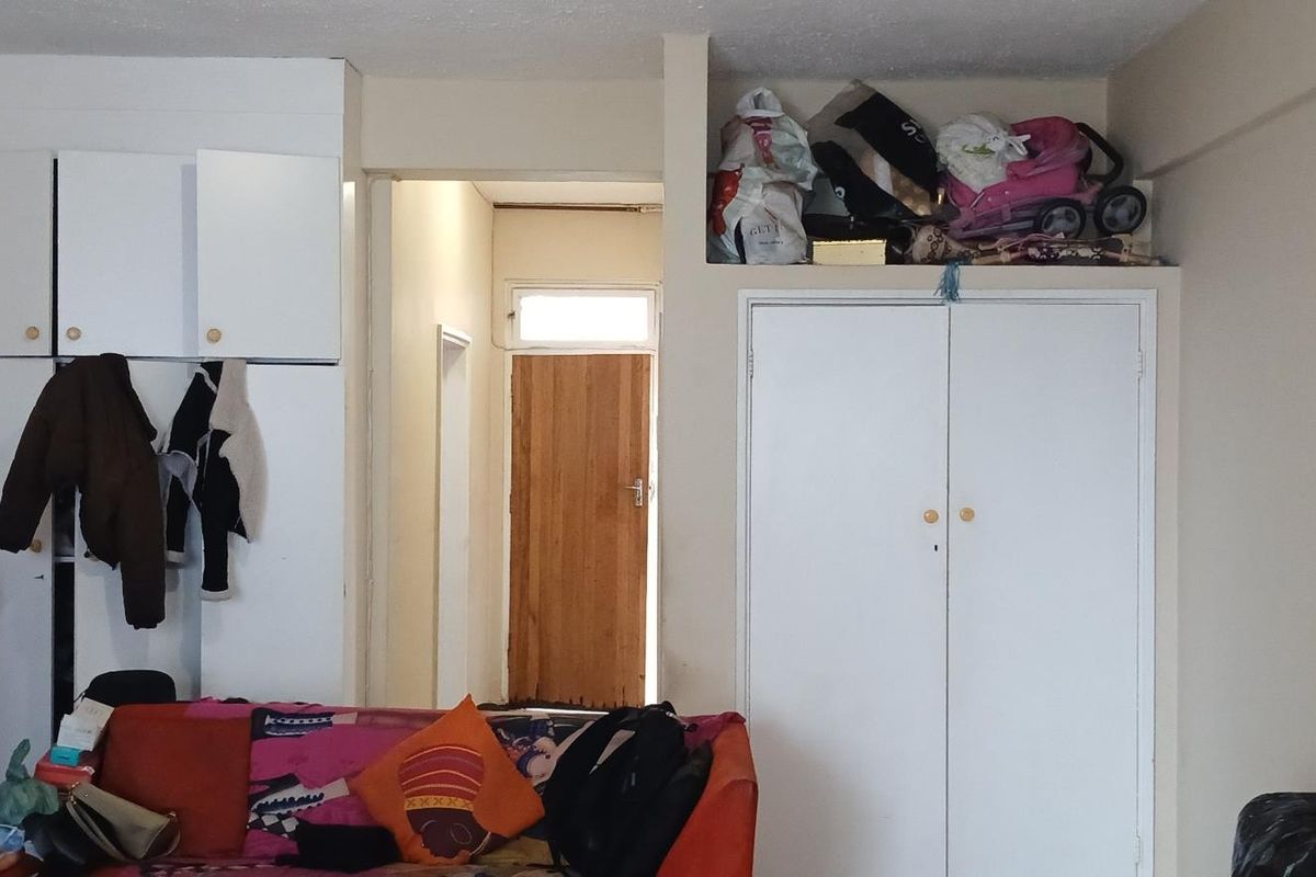 Living room area featuring built-in storage cupboards and access to an internal hallway with a wooden door.