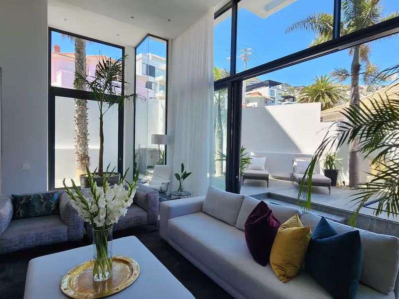 Spacious living room featuring expansive floor-to-ceiling windows and sliding glass doors that provide seamless indoor-outdoor flow to the patio area.