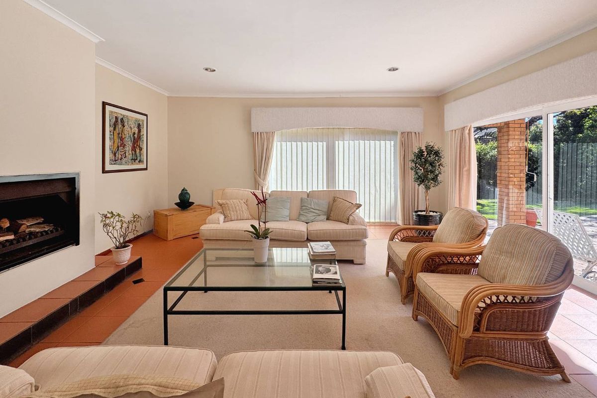 Spacious living room featuring a built-in fireplace with tiled hearth, recessed lighting, and large sliding glass doors providing access to the outdoor area.