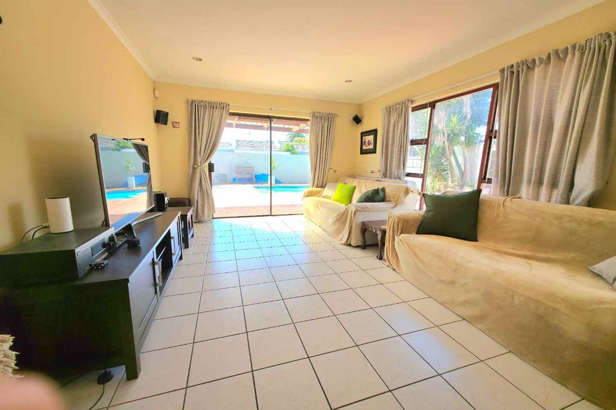 Spacious living room featuring large sliding glass doors that provide direct access to the outdoor pool area.