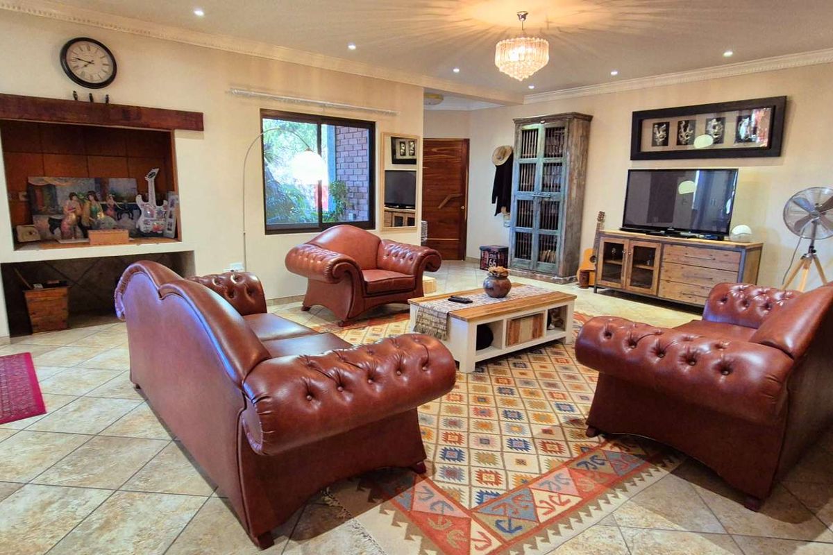 Spacious living room featuring tiled flooring, recessed display shelving, and decorative crown molding, creating a warm and inviting atmosphere.