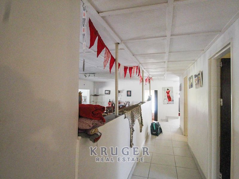 A hallway area featuring tiled flooring and a partial partition wall with a support column, leading into the main living space.