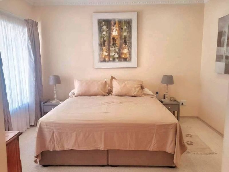 A well-maintained bedroom featuring neutral wall tones, carpeted flooring, and decorative coving, providing a comfortable and functional sleeping space.