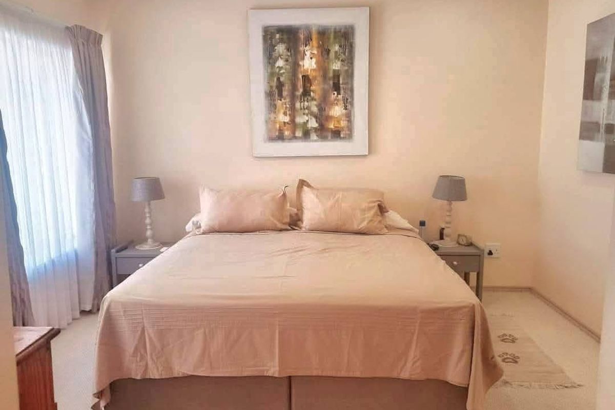 A well-maintained bedroom featuring neutral wall tones, carpeted flooring, and decorative coving, providing a comfortable and functional sleeping space.