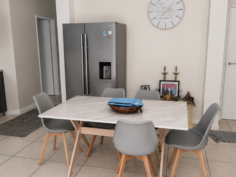 A bright dining area featuring neutral tiled flooring, coved ceiling cornices, and a modern ceiling light fixture, creating a clean and functional space.