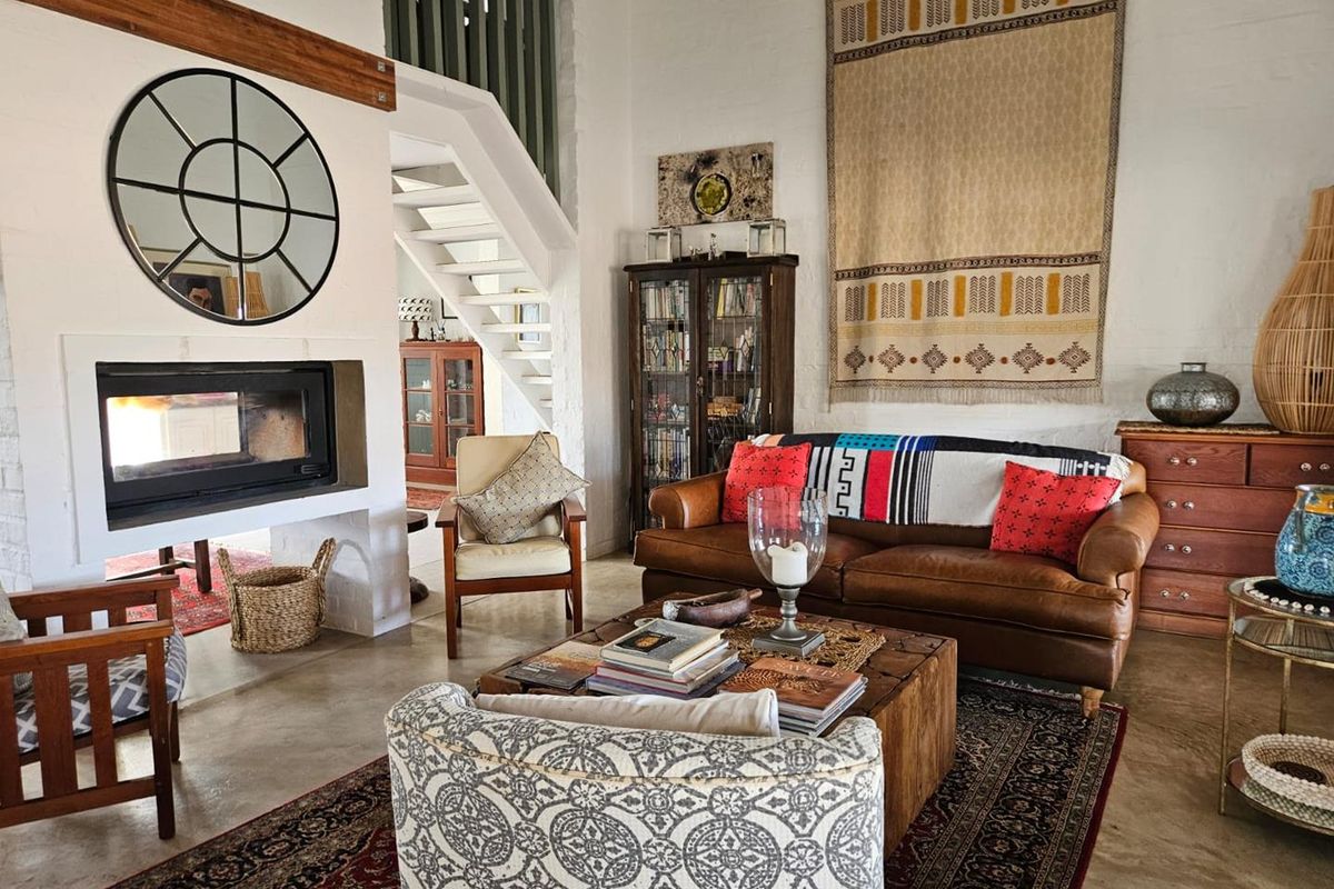 Spacious living room featuring a built-in fireplace, polished concrete flooring, and an open staircase leading to an upper level.