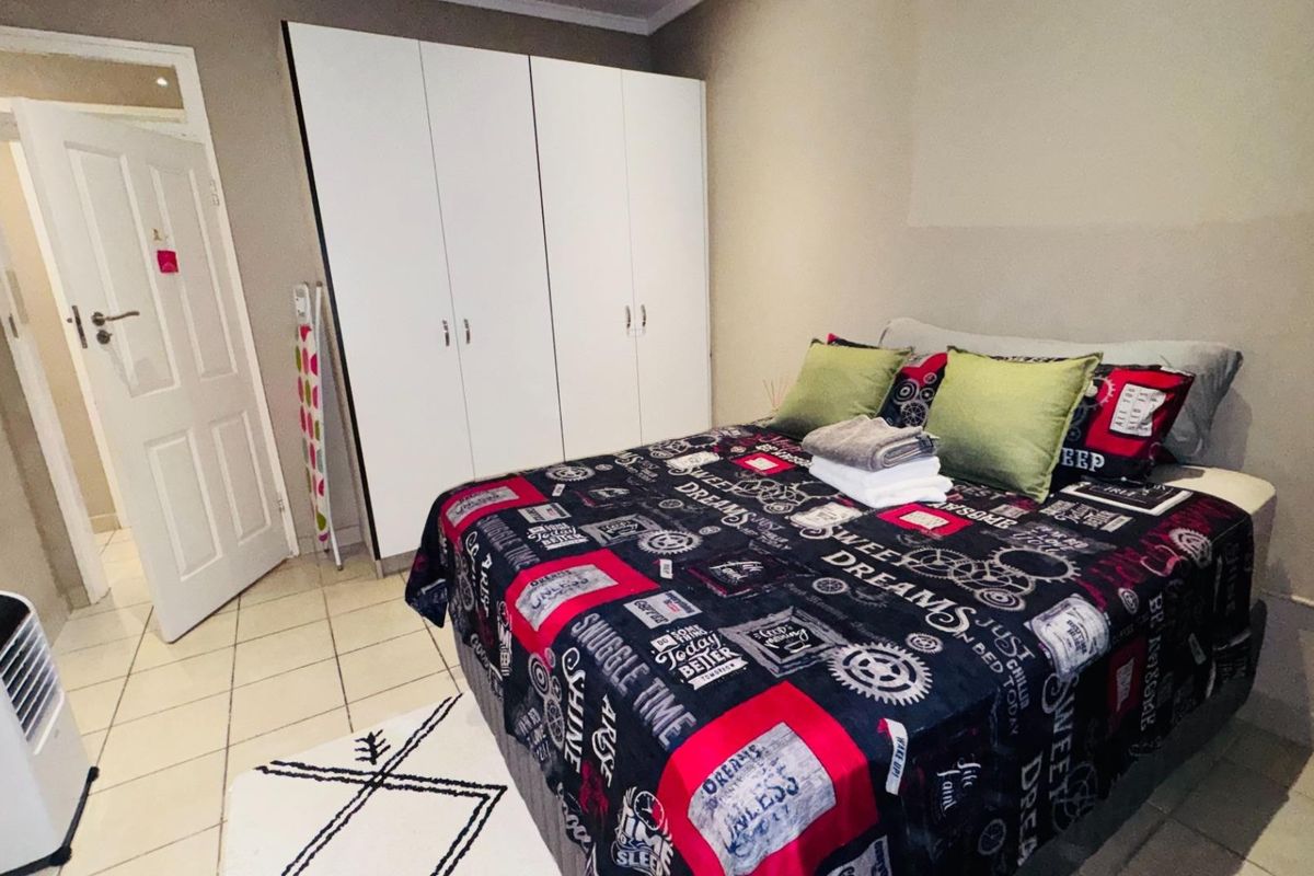 A functional bedroom featuring built-in cupboards and tiled flooring, providing a practical living space.