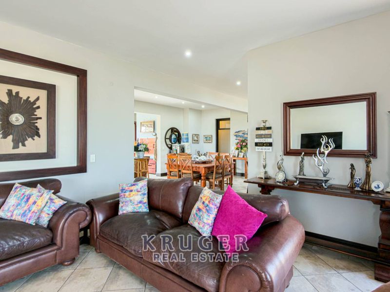 Open plan living and dining area featuring neutral wall tones, tiled flooring, and recessed lighting, creating a connected and functional living space.