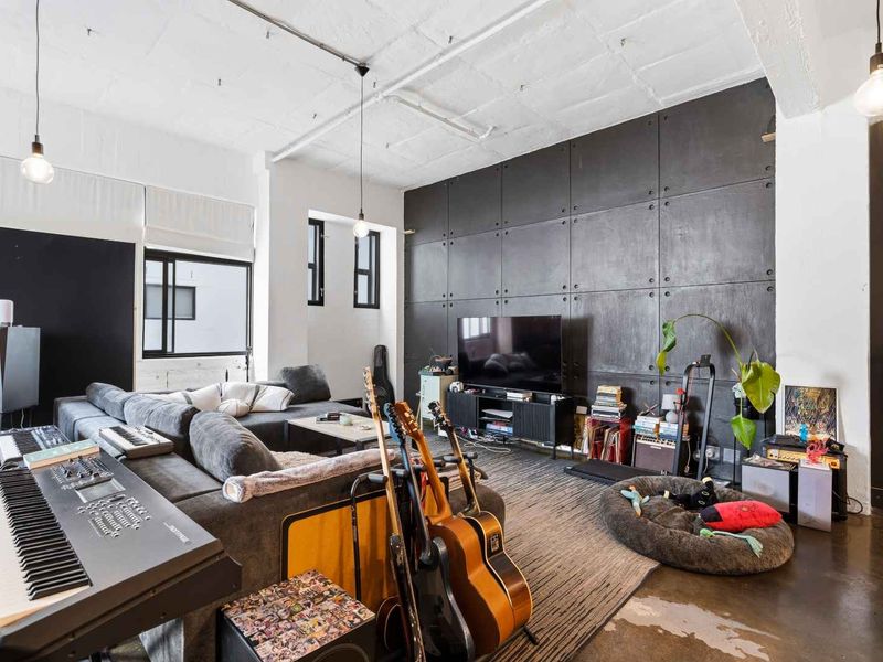 Spacious industrial-style office featuring exposed ceilings, polished concrete floors, and a distinctive dark panelled feature wall.