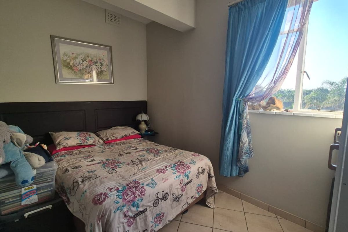 A standard bedroom featuring tiled flooring and a window with natural light, providing a functional space for rest.