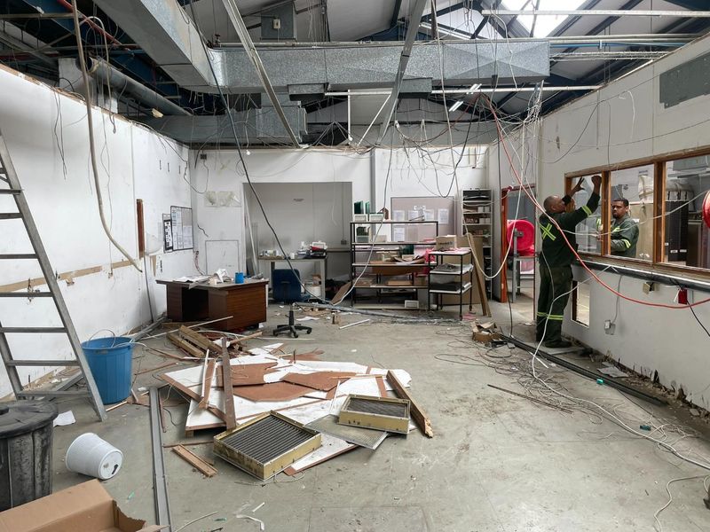 Industrial utility space currently undergoing renovation with exposed infrastructure, unfinished walls, and debris present.