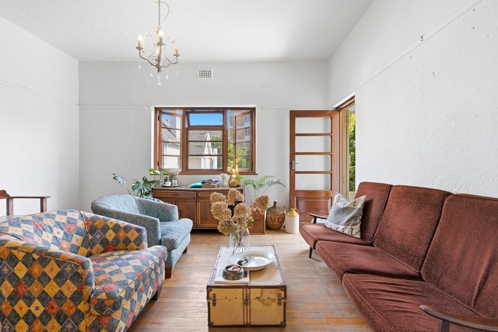 Spacious living featuring original wooden floors and high ceilings 