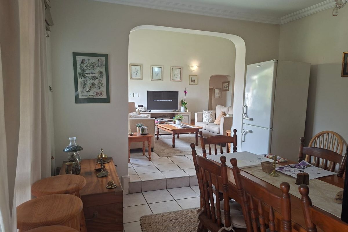 Open-plan living and dining area featuring tiled flooring, an arched transition between spaces, and recessed ceiling lighting.
