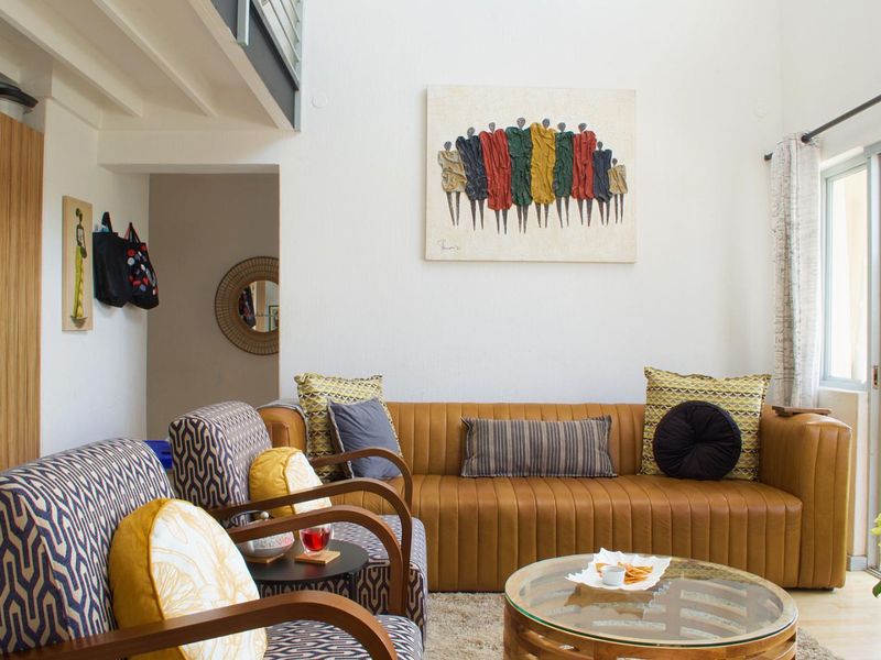 A bright living room featuring laminate flooring, a staircase, and a sliding glass door leading to an outdoor area.