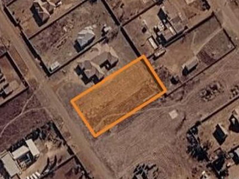 An aerial view of a vacant residential land parcel highlighted in a suburban neighborhood setting.