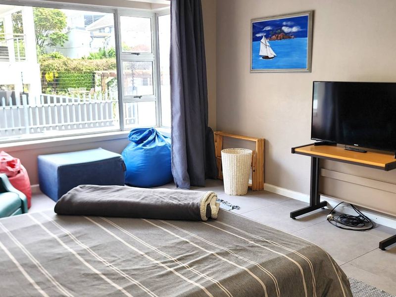 A bedroom featuring large windows that provide natural light and tiled flooring throughout the space.