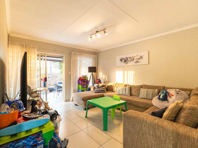 A functional living room featuring tiled flooring and a sliding glass door providing access to the outdoor patio area.