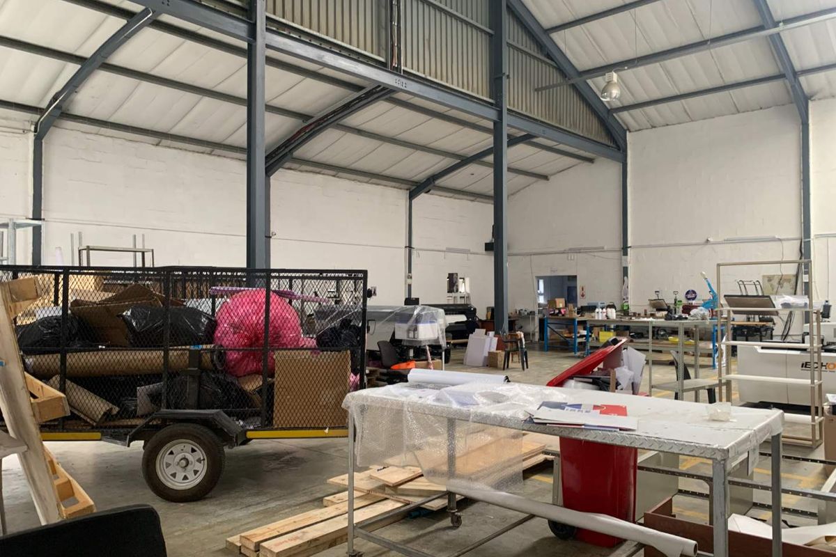 Spacious industrial warehouse unit featuring exposed steel portal frame construction, high-pitched metal roofing, and durable concrete flooring, suitable for various commercial or manufacturing operations.