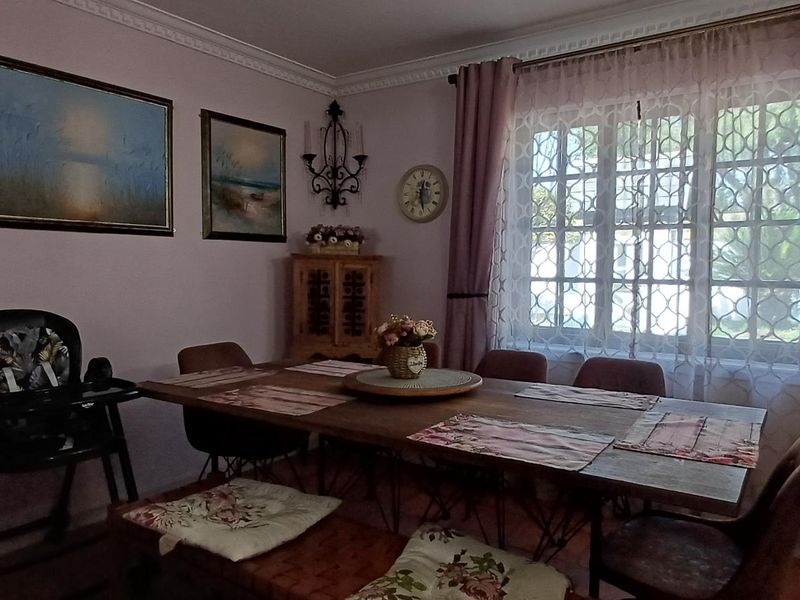 A dining room featuring crown molding, tiled flooring, and a lattice window, providing a cozy space for family meals.