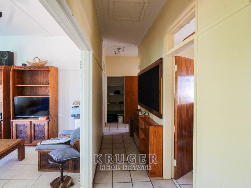 A functional hallway featuring tiled flooring and built-in storage, providing access to adjacent living areas and rooms.