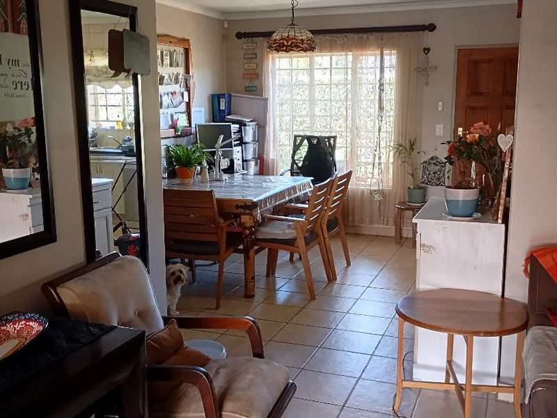 Open plan living and dining area featuring ceramic floor tiles and a sliding glass door providing natural light and access to the exterior.