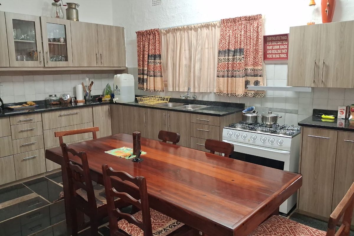 A functional kitchen featuring laminate cabinetry, granite countertops, a double basin sink, and a gas stove, providing a practical workspace for daily cooking.