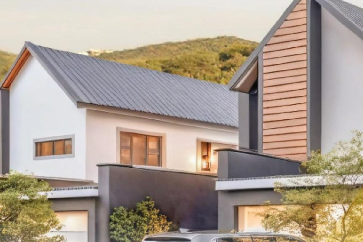 Modern townhouse exterior featuring contemporary architectural design, pitched metal roofing, and clean facade finishes in a scenic setting.