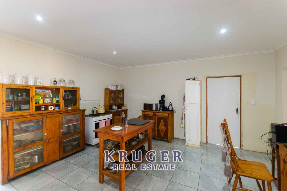 A functional kitchen area featuring tiled flooring, recessed ceiling lighting, and a standard door leading to an adjacent space.