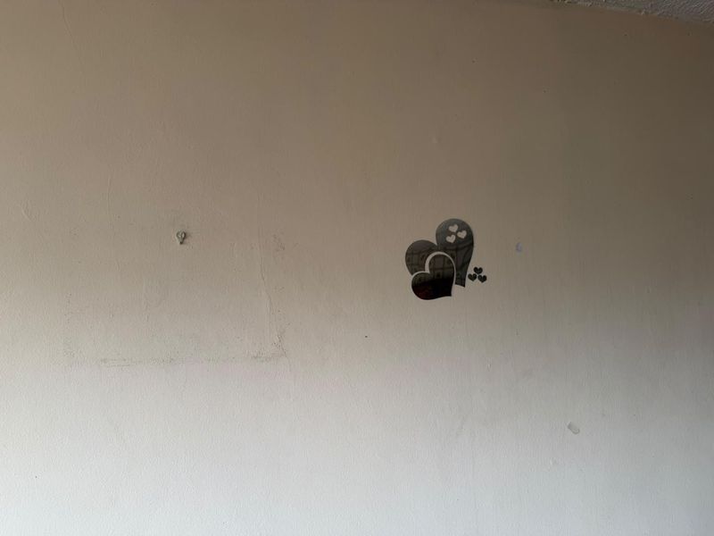 A close-up view of a plain interior wall showing signs of surface wear, paint discoloration, and minor damage from removed fixtures.