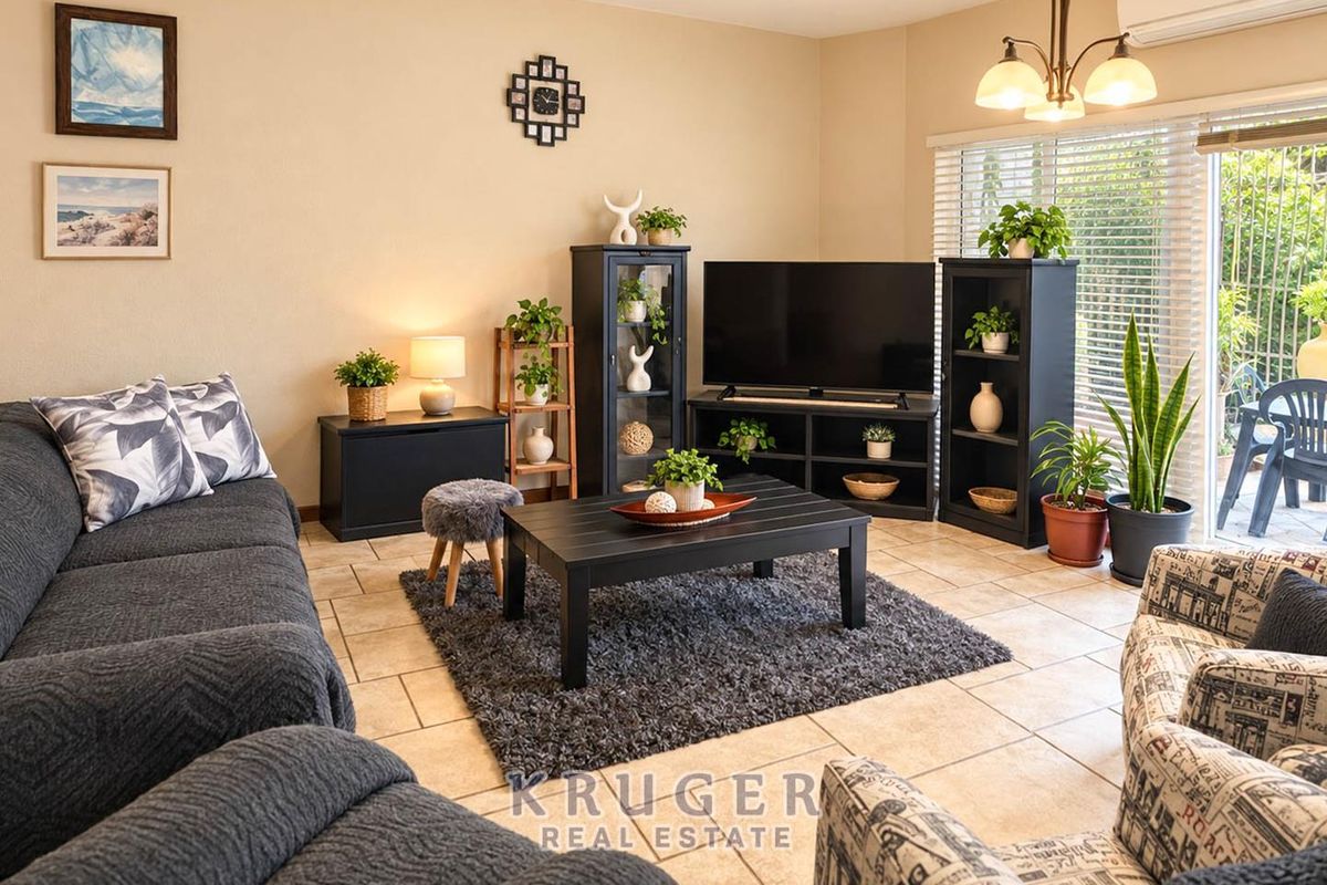 A comfortable living room featuring tiled flooring, a split-system air conditioner, and a sliding glass door providing access to the outdoor area.