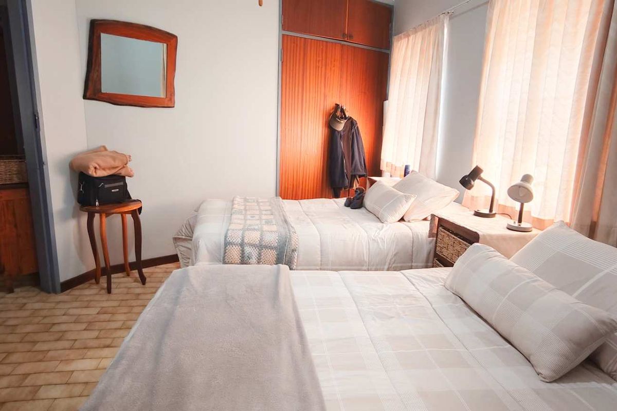 A bedroom featuring built-in wooden cupboards and tiled flooring, providing functional storage and a neutral layout.