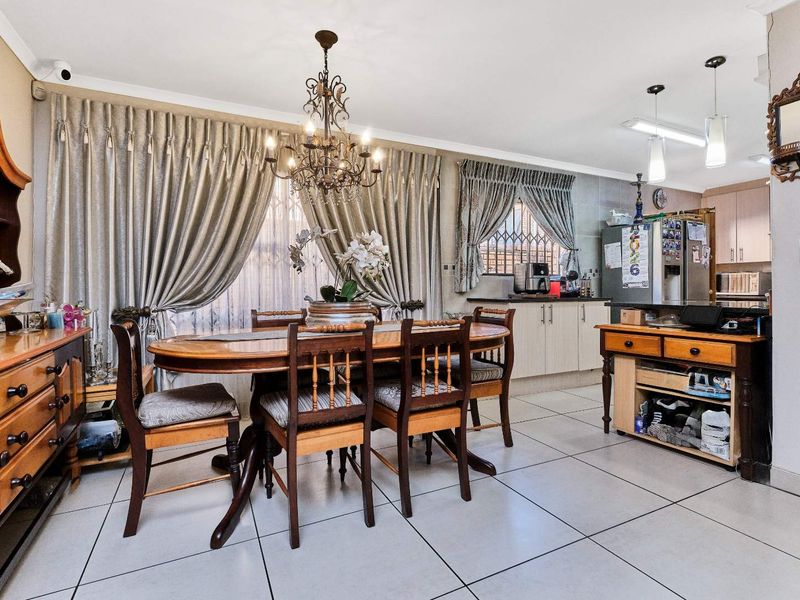 Open-plan dining area featuring tiled flooring and integrated kitchen cabinetry, creating a functional and connected living space.