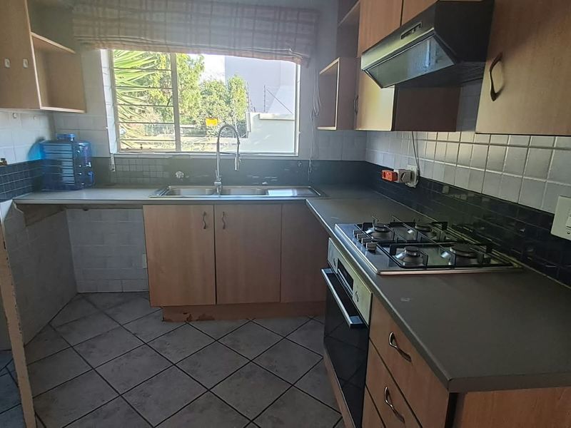 A functional kitchen featuring built-in cabinetry, a gas hob, an oven, and a tiled backsplash, offering a practical layout ready for modernization.