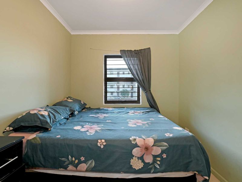 A standard bedroom featuring a window with security bars and simple cove cornicing.