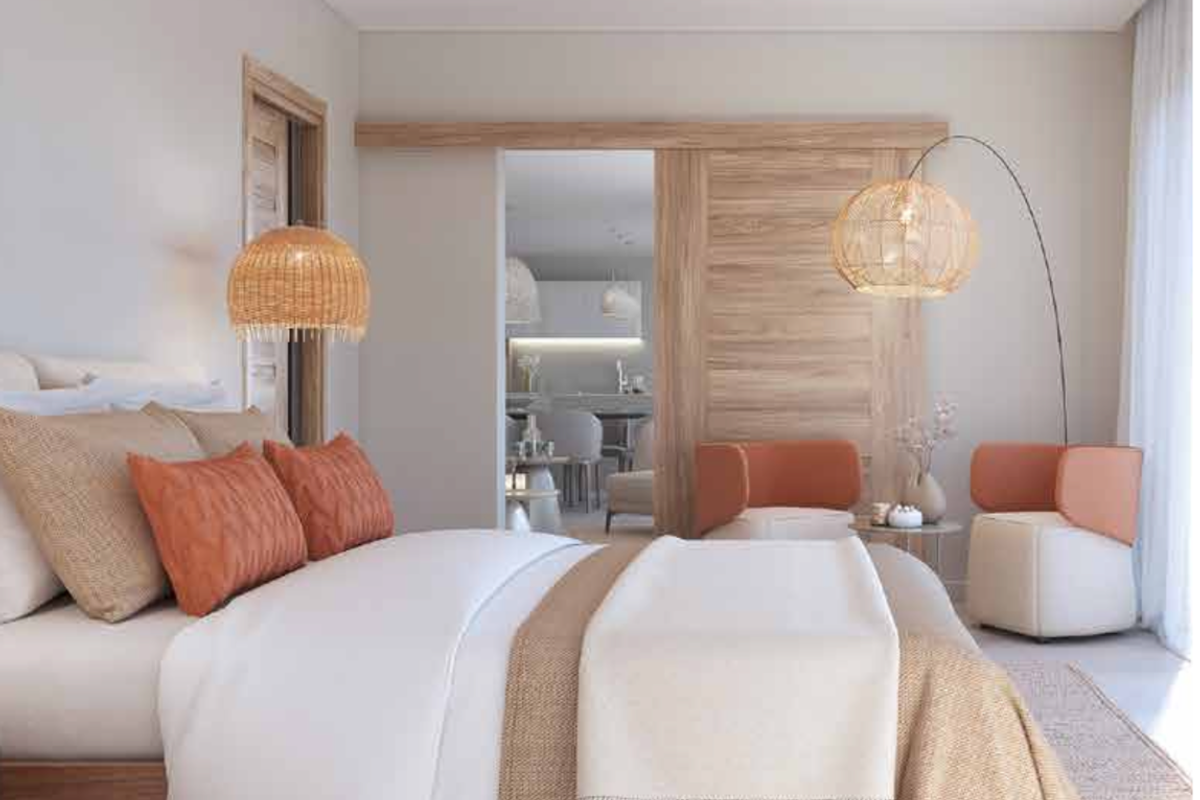 A modern, well-appointed bedroom featuring a wooden sliding door, ceiling fan, and neutral finishes, offering a bright and serene living space.
