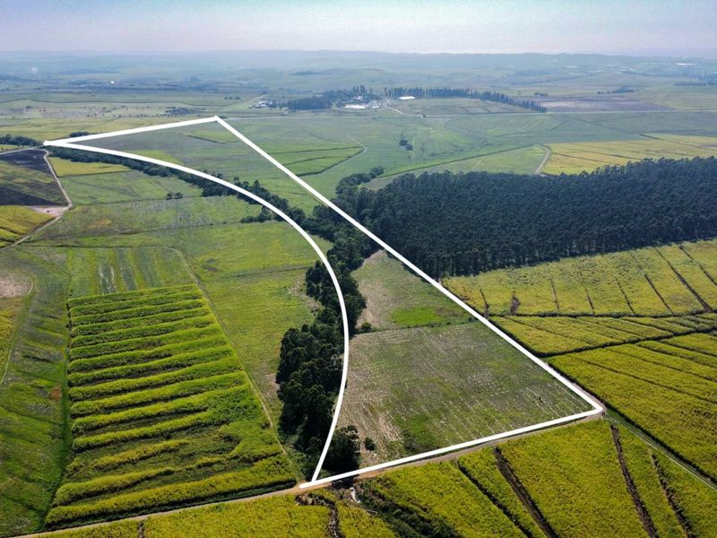 Aerial view of a large agricultural farm plot with clearly marked boundaries, showcasing expansive open fields and surrounding rural landscape.